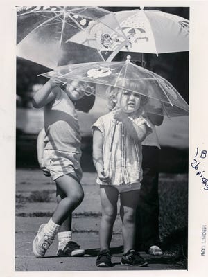 Stacey Nichole McCann (left) goes for a walk under her parasol with friends Katie (front) and Hayley Budd in October of 1986. 