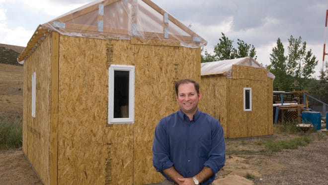 Colorado State University civil engineering professor John van de Lindt stands in front of small houses he is having constructed to do research on using fly ash for insulation, August 3, 2006. Fly ash is a waste product of coal-fired powerplants.