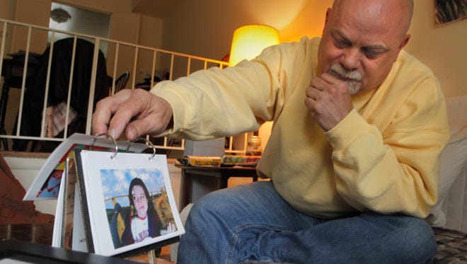 Dave Markham sits in his Fairfield living room with photos of his daughter, Katelyn Markham.