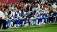 Cowboys players, coaches and staff take a knee prior