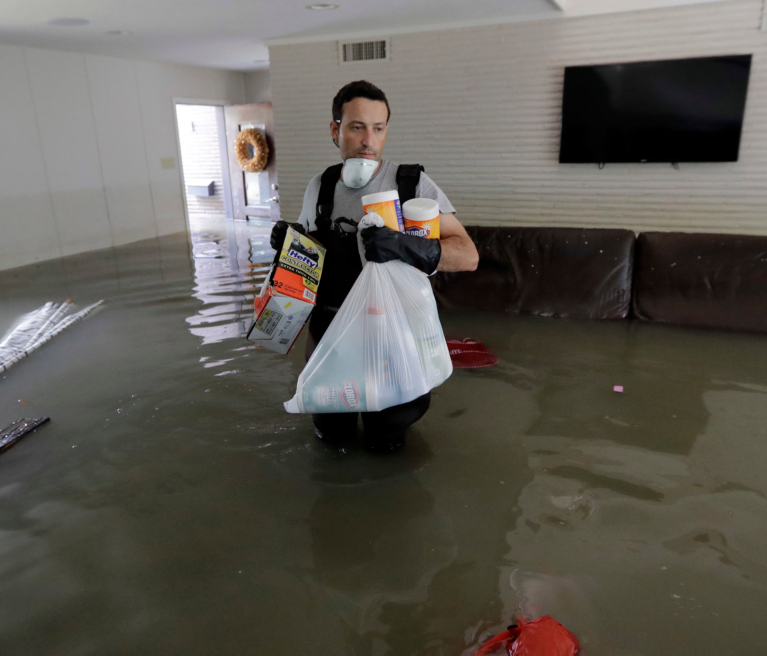 Gaston Kirby walks through floodwater inside his home in the aftermath of Hurricane Harvey, Sept. 4, 2017, near the Addicks and Barker Reservoirs, in Houston.