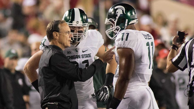 Michigan State coach Mark Dantonio talks with Jamal Lyles during a time-out in the first quarter of MSU's 24-21 loss in overtime to Indiana on Saturday, Oct. 1, 2016 in Bloomington, Ind.