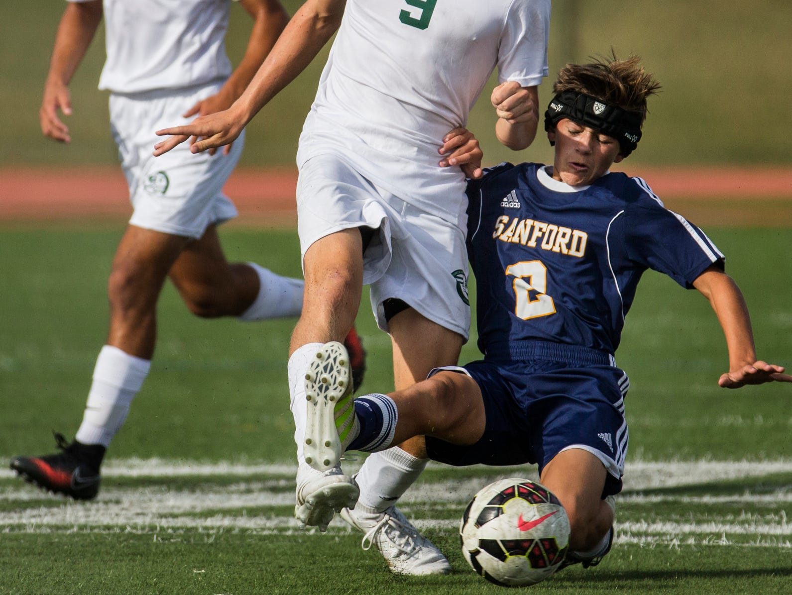 Sanford's Trent Wall (No. 2) slides in front of Tower Hill's Drew Manning (No. 9) on a tackle in the first half of Tower Hill's 3-1 win over Sanford at Tower Hill School in Wilmington on Wednesday afternoon.