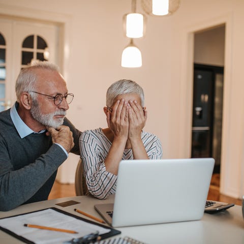 Older couple looking at laptop in dismay.