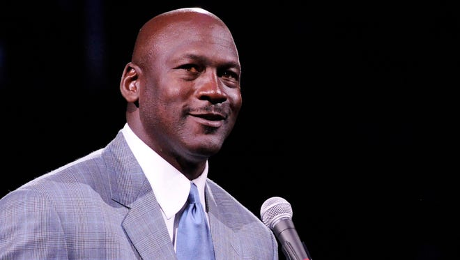 Dec 21, 2013; Charlotte, NC, USA; Charlotte Bobcats owner Michael Jordan unveils the new Charlotte Hornets logo at halftime during the game against the Utah Jazz at Time Warner Cable Arena.