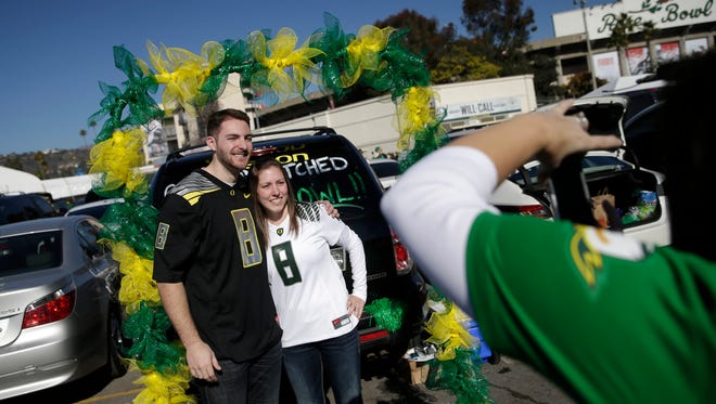 Oregon fans Steve Twomey and Lisa DeFluri pose for a photo outside the stadium before the Rose Bowl NCAA college football playoff semifinal game between Florida State and Oregon, Thursday, Jan. 1, 2015 in Pasadena, Calif.
