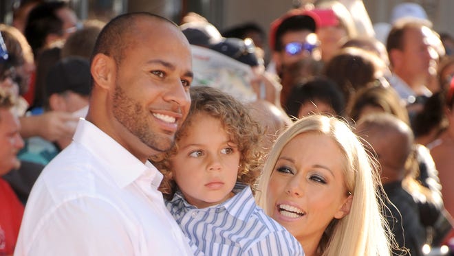 Hank Baskett, son Hank and TV personality Kendra Wilkinson arrive at the Los Angeles premiere of 'Planes' at the El Capitan Theatre on Aug. 5, 2013 in Hollywood.