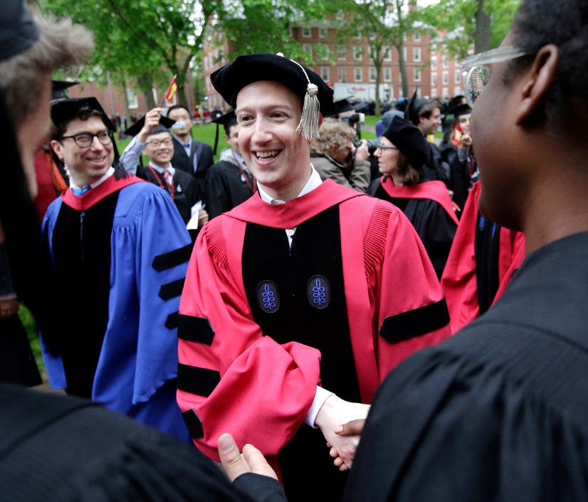 Facebook CEO and Harvard dropout Mark Zuckerberg, center, greets graduating Harvard students as he walks in a procession though Harvard Yard at the start of Harvard University commencement exercises, Thursday, May 25, 2017, in Cambridge, Mass.