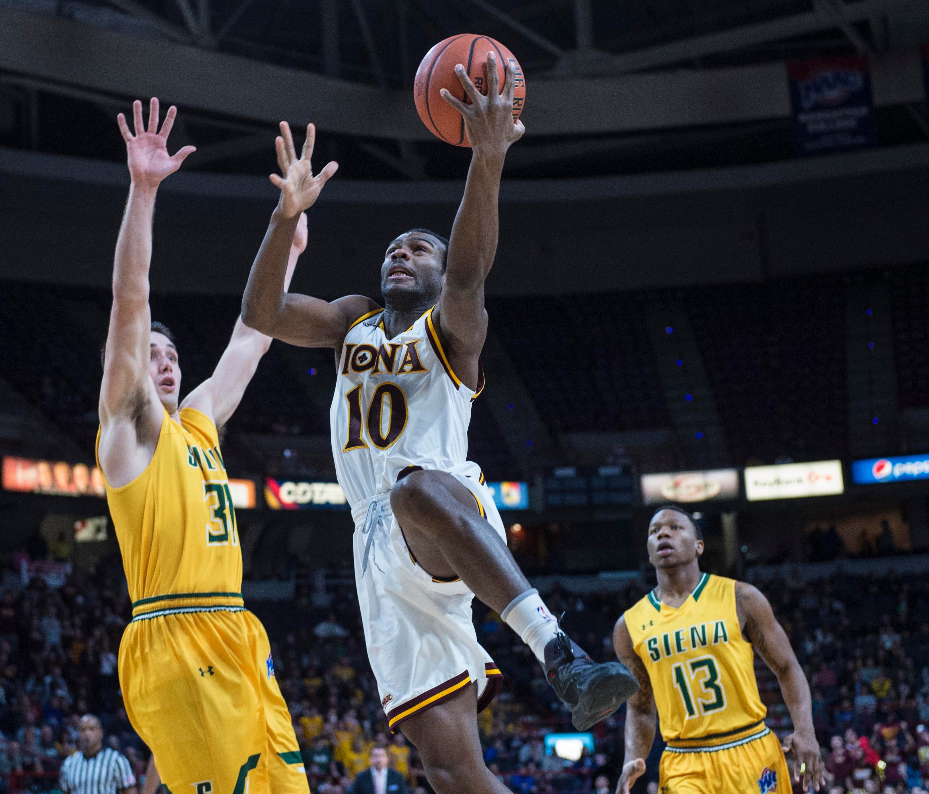 Iona guard Jon Severe drives to the basket against Siena's Brett Bisping at Times Union Center in Albany, N.Y.