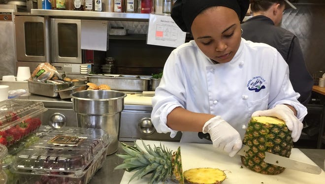 Sherries (“Blu”) Anderson cuts a pineapple for a fruit tray at The Classroom restaurant in west Redding.