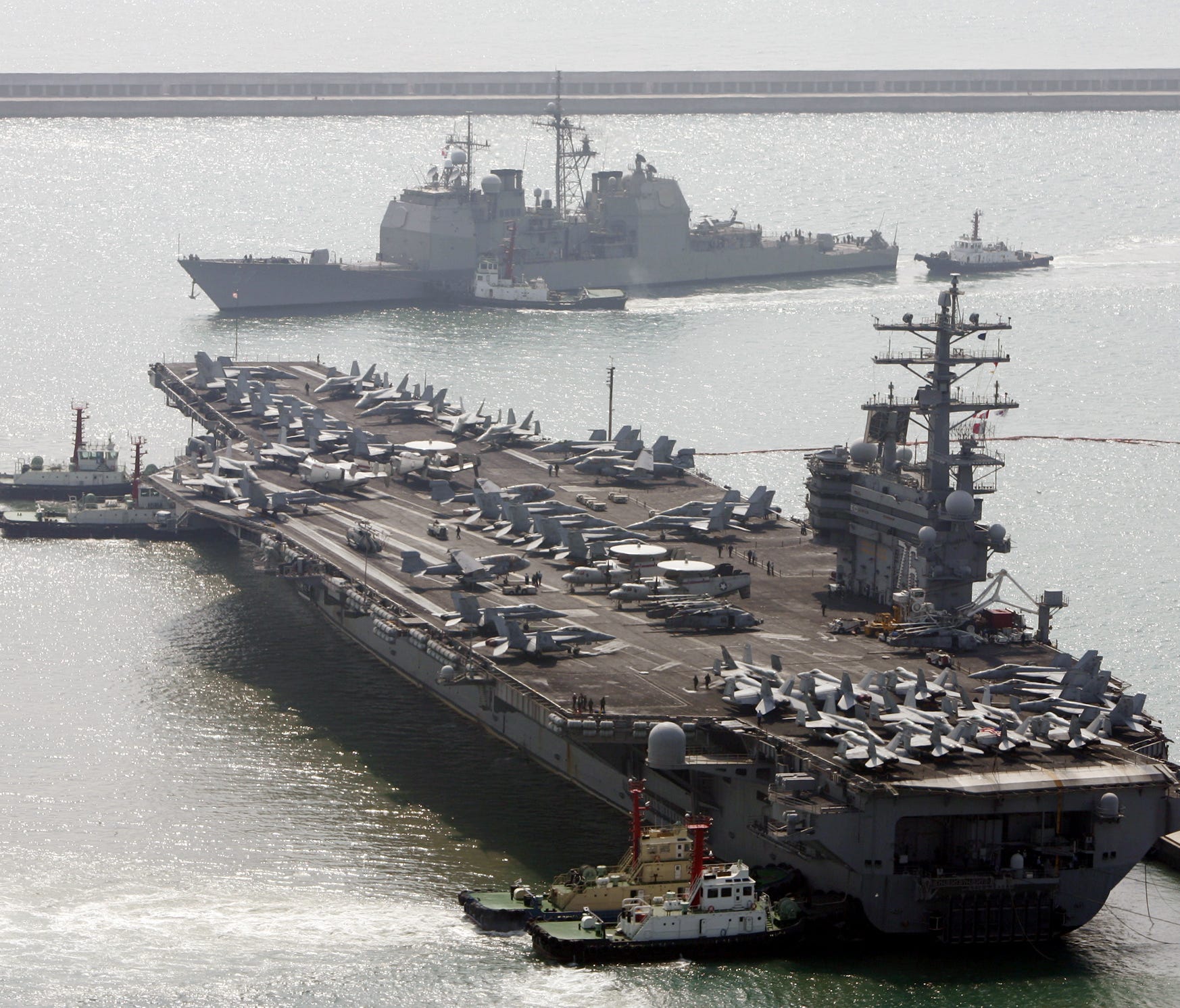 In this March 22, 2007, file photo, the U.S. aircraft carrier USS Ronald Reagan, bottom, anchors as U.S. Aegis Ship passes after they arrive at Busan port for joint military exercises in Busan, South Korea.