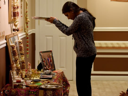 Chaitali Shah prays before the altar with a ghee lamp during Diwali. A photograph of Rekhaben Shah, 67 holds a special place on the altar.