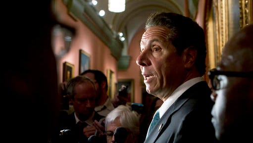 New York Gov. Andrew Cuomo talks to media members outside his office at the state Capitol on Tuesday, May 24, 2016, in Albany, N.Y. Cuomo says tightening campaign finance laws and fighting the heroin epidemic are two of his top priorities as lawmakers near adjournment.