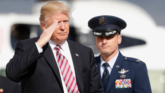 President Donald Trump returns a salute before boarding Air Force One from Andrews Air Force One, Md.
