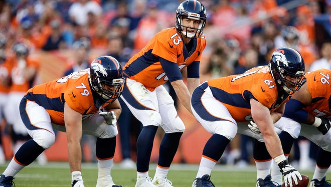 Denver Broncos quarterback Trevor Siemian (13) looks over center Matt Paradis (61) and tackle Michael Schofield (79) at the line of scrimmage in the first quarter against the San Francisco 49ers at Sports Authority Field at Mile High on August 20, 2016 in Denver.