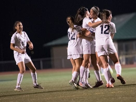 The Trojans celebrate after Lauren Ocker (5) scored