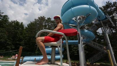 With the water slide in the background, lifeguard Mikey Hubacek watches over the pool in summer 2013 at the Rothschild-Schofield Aquatic Center in Rothschild.