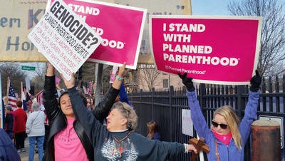 A Planned Parenthood supporter and opponent try to block each other's signs Feb. 11, 2017, during a protest and counter-protest in St. Louis.
