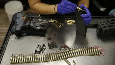 An employee loads up a magazine for an automatic machine gun at Machine Guns Vegas in Las Vegas. Shooting ranges with high-powered weapons have become a hot tourist attraction.;
