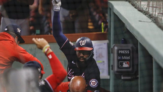 Washington Nationals' Josh Harrison rides on the back of a Nationals employee as he celebrates his two-run home run in the dugout during the eighth inning of a baseball game against the Boston Red Sox, Friday, Aug. 28, 2020, at Fenway Park in Boston.
