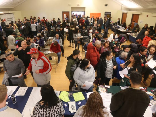 A packed room of families from Puerto Rico attend a welcome reception at the Ibero-American Action League where two dozen agencies came together to provide aid to the families.