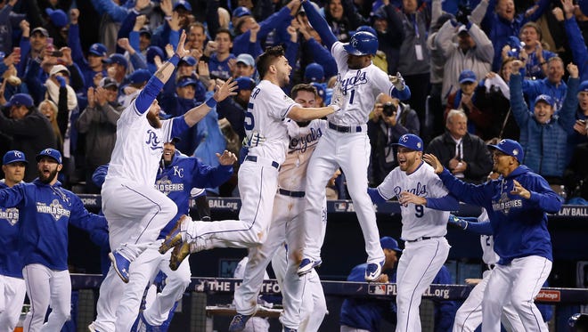 Kansas City Royals players celebrate after Alcides Escobar scored on a sacrifice fly by Eric Hosmer during the 14th inning of Game 1 of the World Series against the New York Mets Wednesday, Oct. 28, 2015, in Kansas City, Mo.