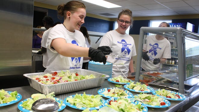 From left, Sarah Spencer, 18, SaVanna Finkbeiner, 19, and Alexia Gillette, 18, all of Endwell, serve salad at Thursday's spaghetti dinner fundraiser at Maine-Endwell High School.