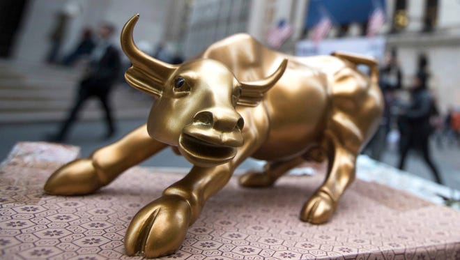 A miniature reproduction of Arturo Di Modica's "Charging Bull" sculpture sits on display at a street vendor's table outside the New York Stock Exchange, in lower Manhattan. U.S. Stocks are rising Tuesday, Aug. 1, 2017, as payment processors and banks trade higher. 