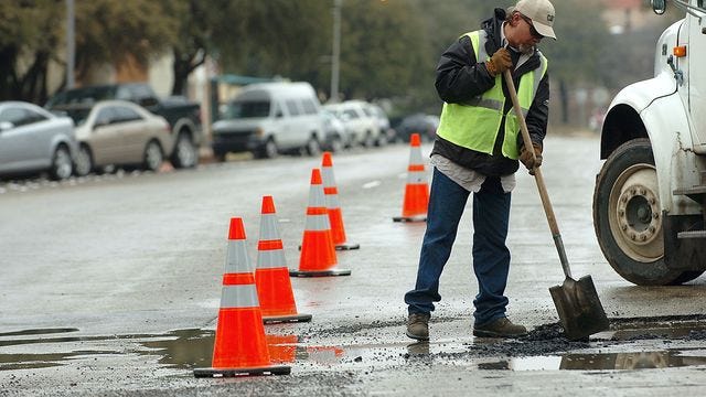 Victor Cristales/Reporter-News City of Abilene street services worker Gerald Lewis fills a pothole at the intersection of South 4th and Chestnut streets after a rain shower on Thursday, Feb. 4, 2010.