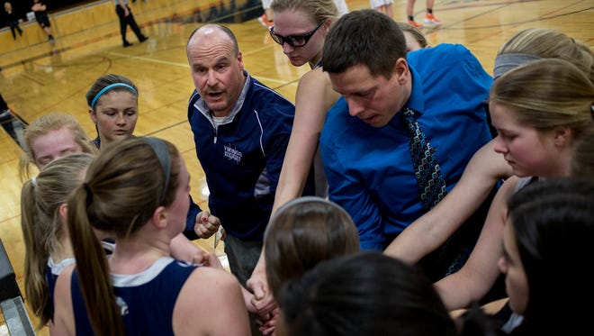 Assistant Coach Tom Valko puts his hand in a huddle with the team on the sideline during a basketball game Tuesday, Feb. 2, 2016 at Marine City High School.