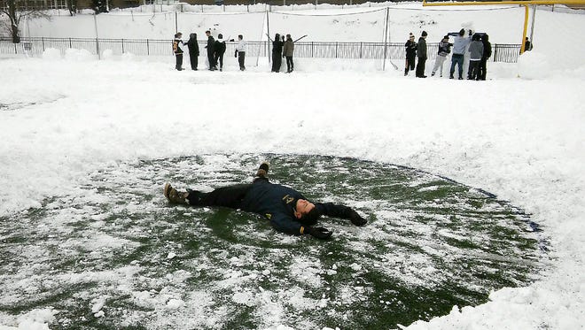Jefferson senior goalie Anthony Gambuti stretches out after clearing the snow from the crease.