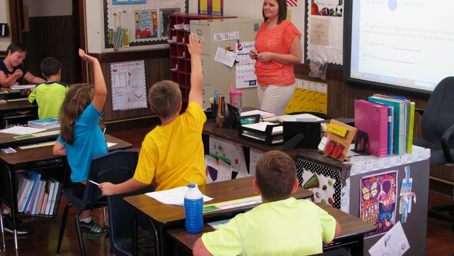 FILE - In this Sept. 18, 2013 photo, Shelly Ellis teaches fourth-grade students in a newly air conditioned classroom at Bement Elementary School in Bement, Ill. The results of the latest Nation’s Report Card are in and the news isn’t good. Fourth-graders made no improvements in math or reading, while eighth-graders’ scores were flat in math and only slightly improved in reading. Overall, only roughly a third of American eighth-graders are proficient in reading and math along with about 40 percent of fourth-graders.