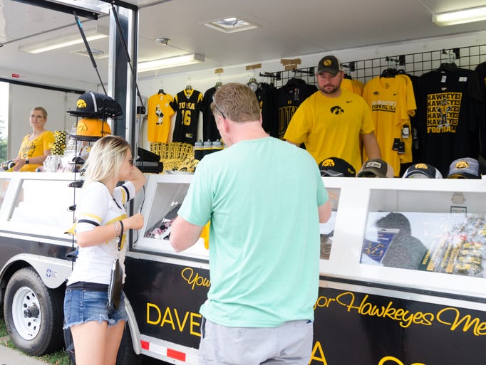 Two people buy Hawkeye merchandise before the Iowa