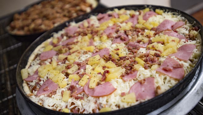 A Hawaiian pizza sits ready for the oven at Panhandler's Pizza on W. Elizabeth Street on Wednesday, July 26, 2017. Owner John Olson has announced that he will not continue operating the business in another location after Panhandler's serves its last slice on Elizabeth Street on September 24.
