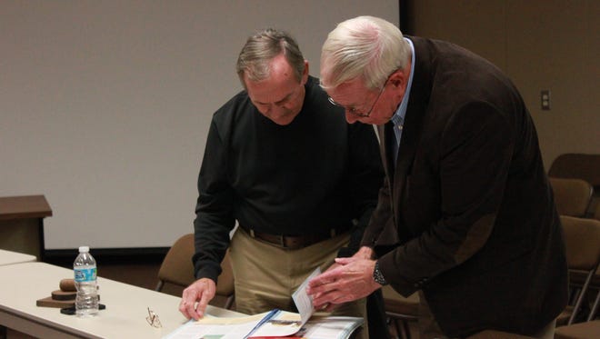 Madison County Commissioner Gerry Neese, left, and Jackson-Madison County School Board Chairman Jim Campbell, right, look through the seventh-grade social studies book.