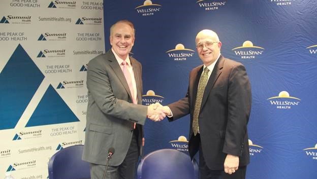 Summit Health CEO Patrick O’Donnell, left, and WellSpan CEO Kevin Mosser shake hands Tuesday, April 3, during the announcement of a potential merger.