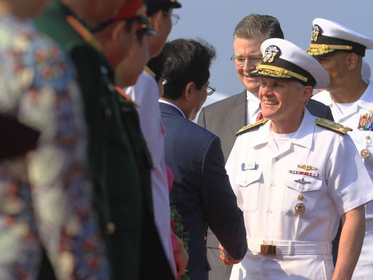 Vice Admiral Phillip G. Sawyer, right, commander of the U.S. Navy's 7th Fleet, greets Vietnamese officials after the aircraft carrier USS Carl Vinson pulled into port in Da Nang on March 5, 2018.