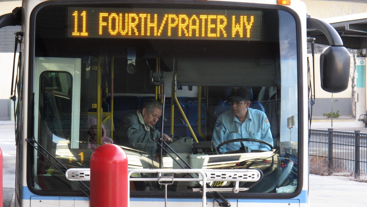 A passenger boards a city bus while the driver looks on at the bus station in downtown Reno on March 2, 2016.