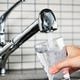 Someone filling a glass with tap water.