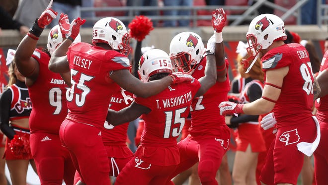 Louisville's Trumaine Washington celebrates with teammates after returning an interception for a touchdown. Nov. 7, 2015