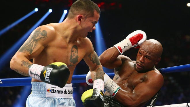 Marcos Maidana gets Floyd Mayweather Jr. against the ropes during their first fight at MGM Grand. They will meet again on Saturday.