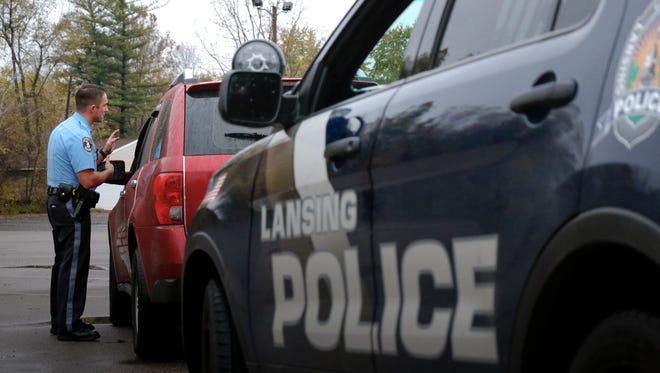 Officer Joe Riedel of the Lansing Police Department speaks to a driver during a traffic stop on Lansing's south side on Thursday, Nov. 2, 2017.  Lansing police officers wear body cameras while on patrol.