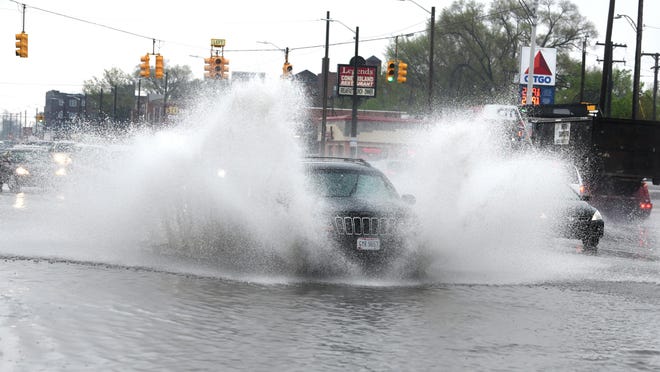 Motorist splash through flooded lanes along Linwood and W. Davidson in Detroit on Saturday.