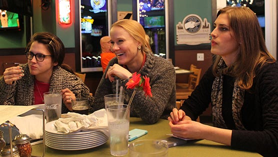 Team members mull over possible trivia answers while munching on pizza.