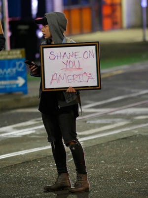 Felomina Cervantes, of Seattle, holds a sign that reads "Shame on You America" as she takes part in a protest against President-elect Donald Trump, Wednesday, Nov. 9, 2016, in Seattle's Capitol Hill neighborhood.