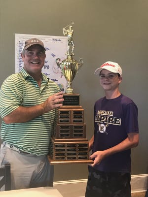 Robby McWilliams (left) and son Noah pose with the City Am trophy Sunday.