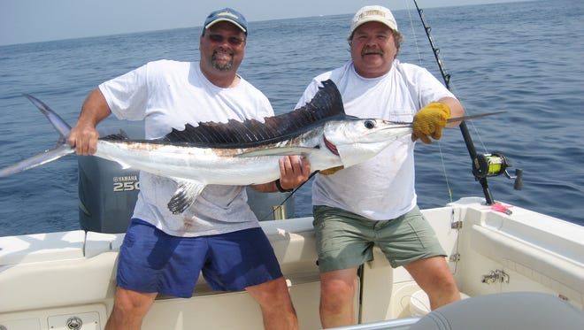 File: Pictured is Dom Tepfer with his first white marlin catch and release. Helping him hold the fish on the right is Jeff Barnhart. They caught the fish on Bob Percopo's boat No Limits.