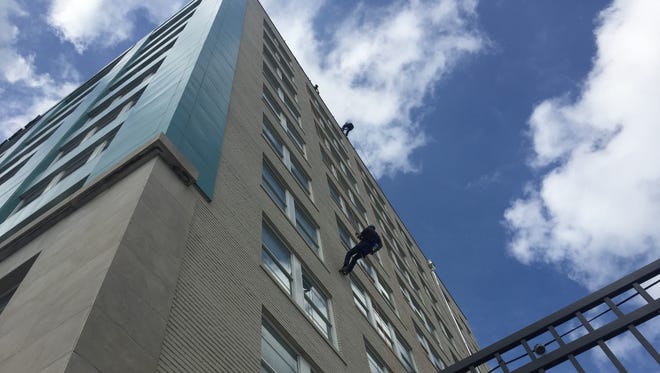A man rappels down the side of Sky Eleven in downtown Springfield on Saturday, June 3.