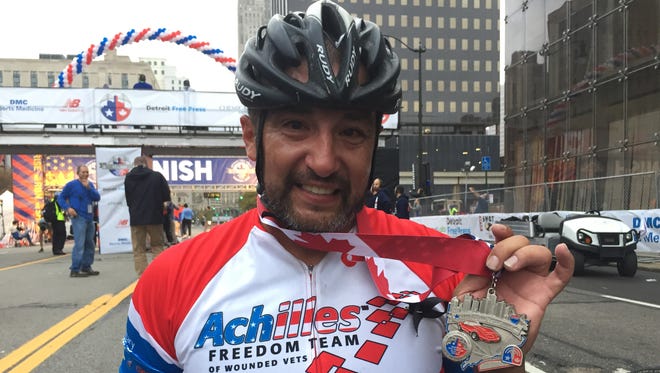 Omar Duran, 38, of Clearwater, Fla., shows off his medal after coming in first among the hand cycle marathoners in today's Detroit Free Press/Chemical Bank Marathon -- with a time of about 1 hour, 22 minutes -- despite having the left handle of his hand crank come off in the last mile. "I just held onto what was left and kept going," he said.