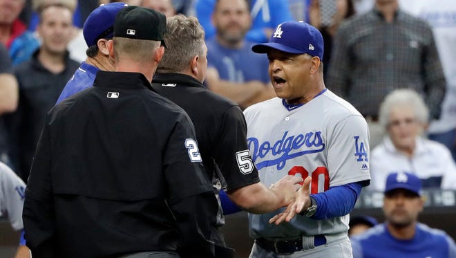 Dodgers manager Dave Roberts argues with umpires on Friday night in San Diego after he got into a shouting match with Padres manager Andy Green over stealing signs.